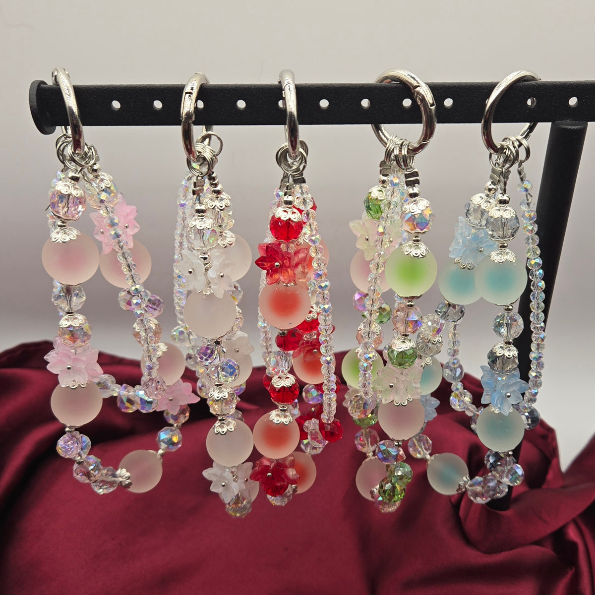 Frosted Blossoms beaded phone charms in pink, white, red, green and blue floral designs