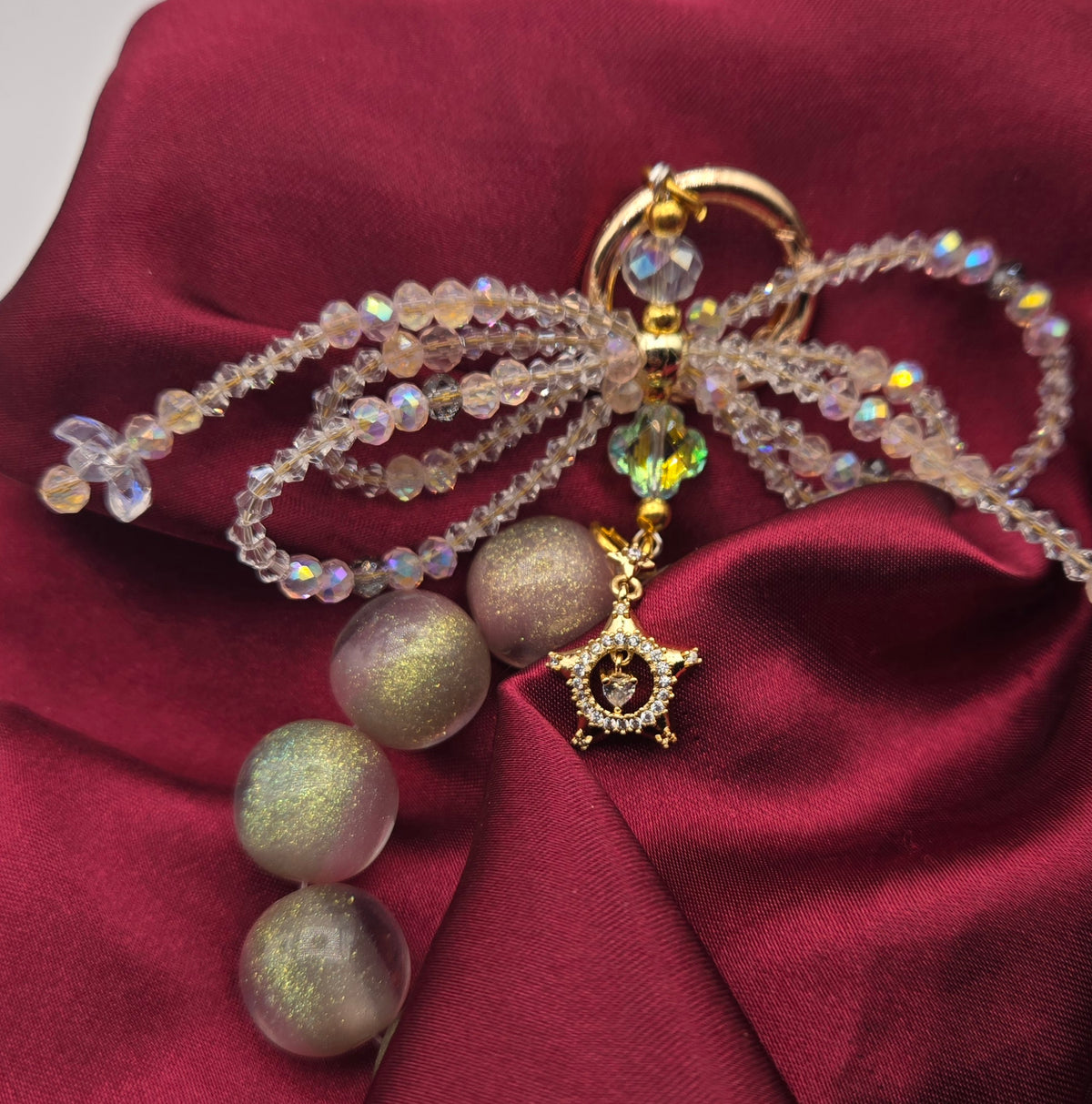 Starlit Bow phone charm with blush shimmer beads, crystal bow and gold star detail