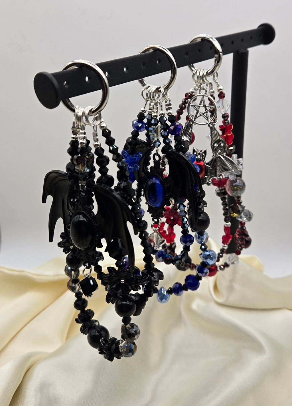 Three gothic bat phone charms in black, blue and red with layered beads and silver-tone details