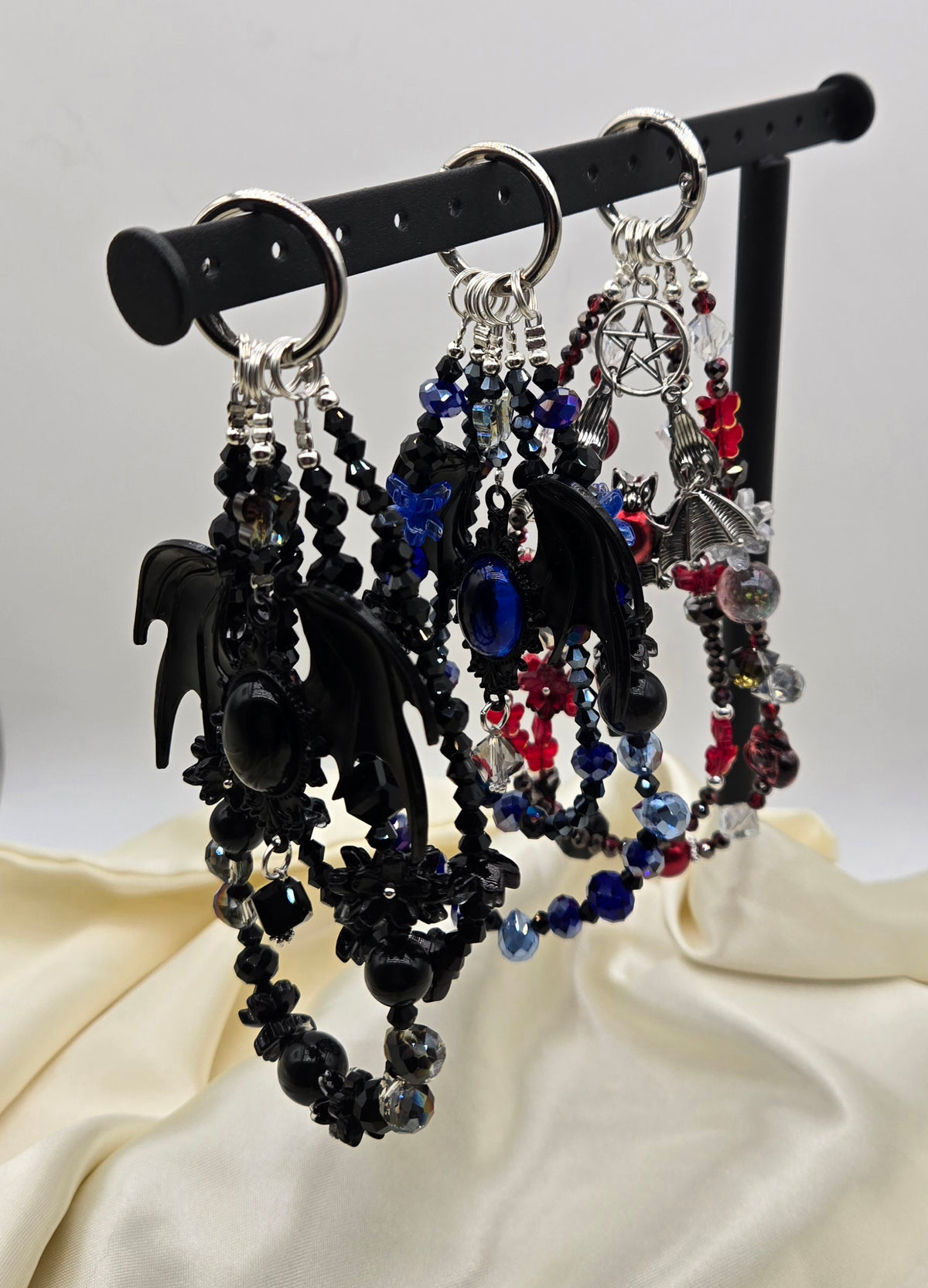 Three gothic bat phone charms in black, blue and red with layered beads and silver-tone details