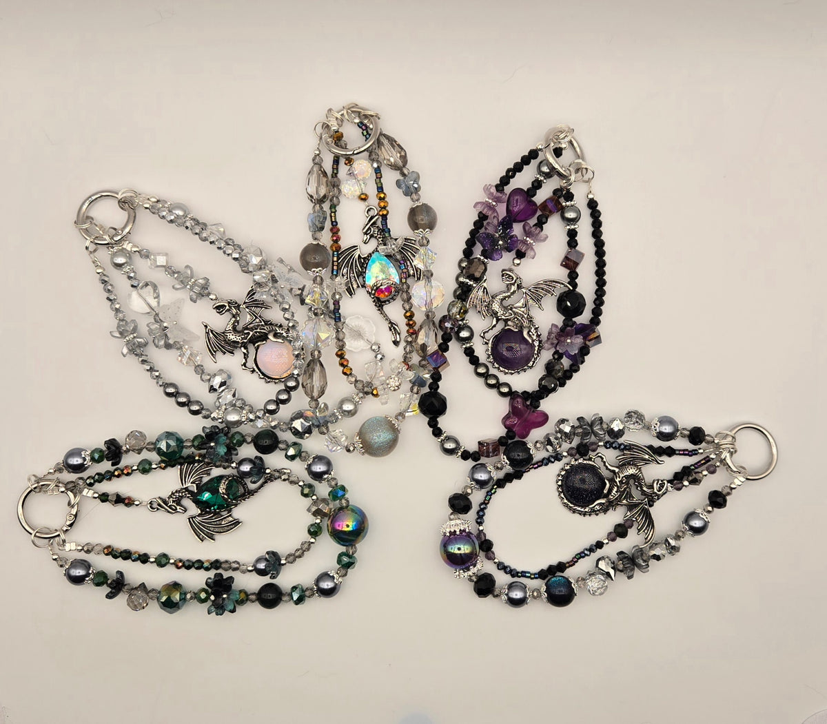 Assorted Dragon Magic multi-strand beaded phone charms with silver-tone dragon designs