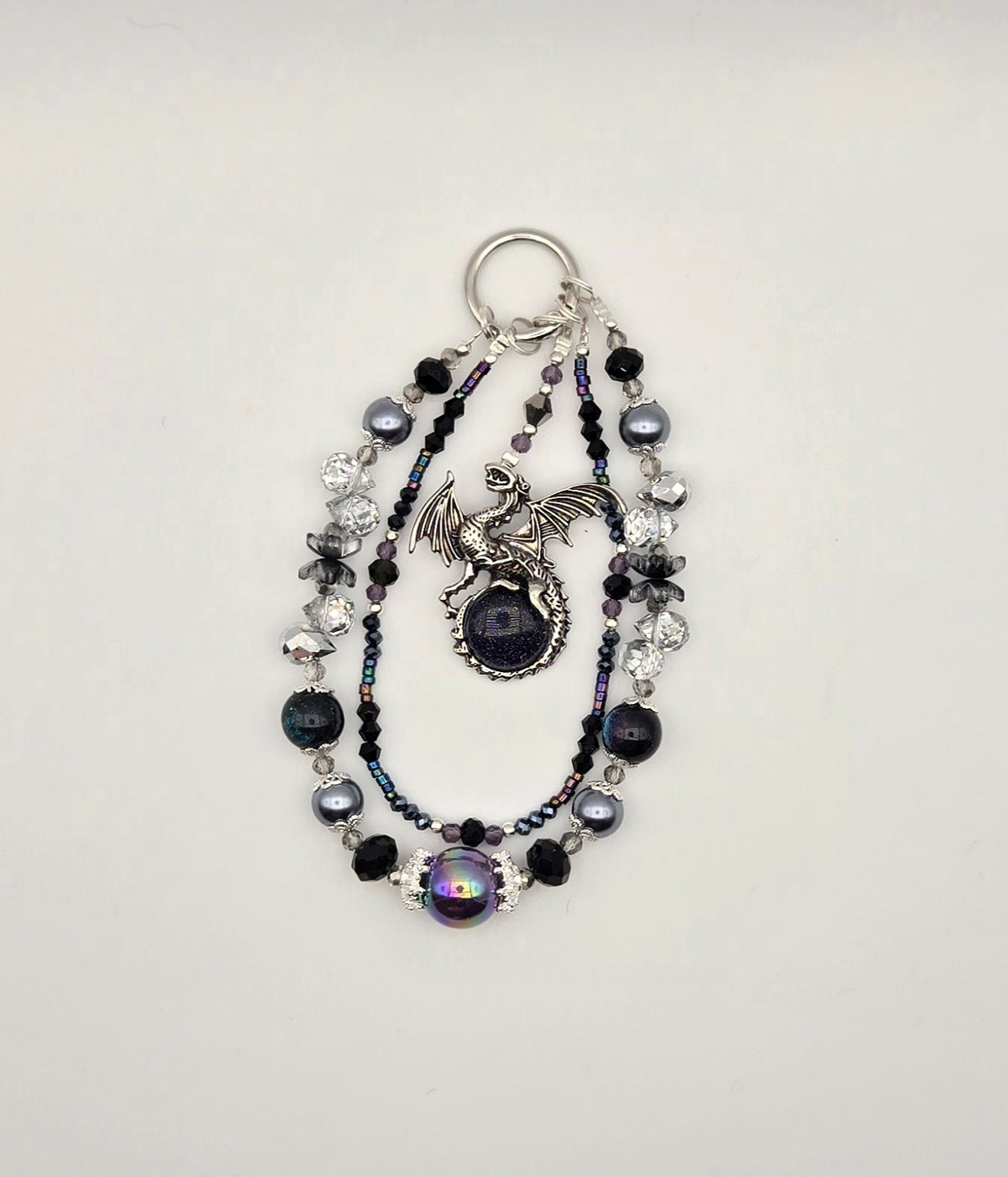 Night Guardian phone charm with black and deep blue beaded strands and silver-tone dragon focal