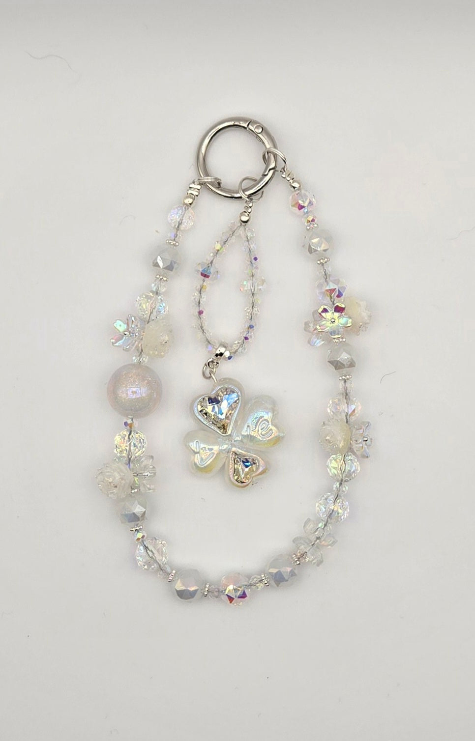 Crystal Wish Enchanted Clover phone charm with clear iridescent beads, floral accents and four-leaf clover focal