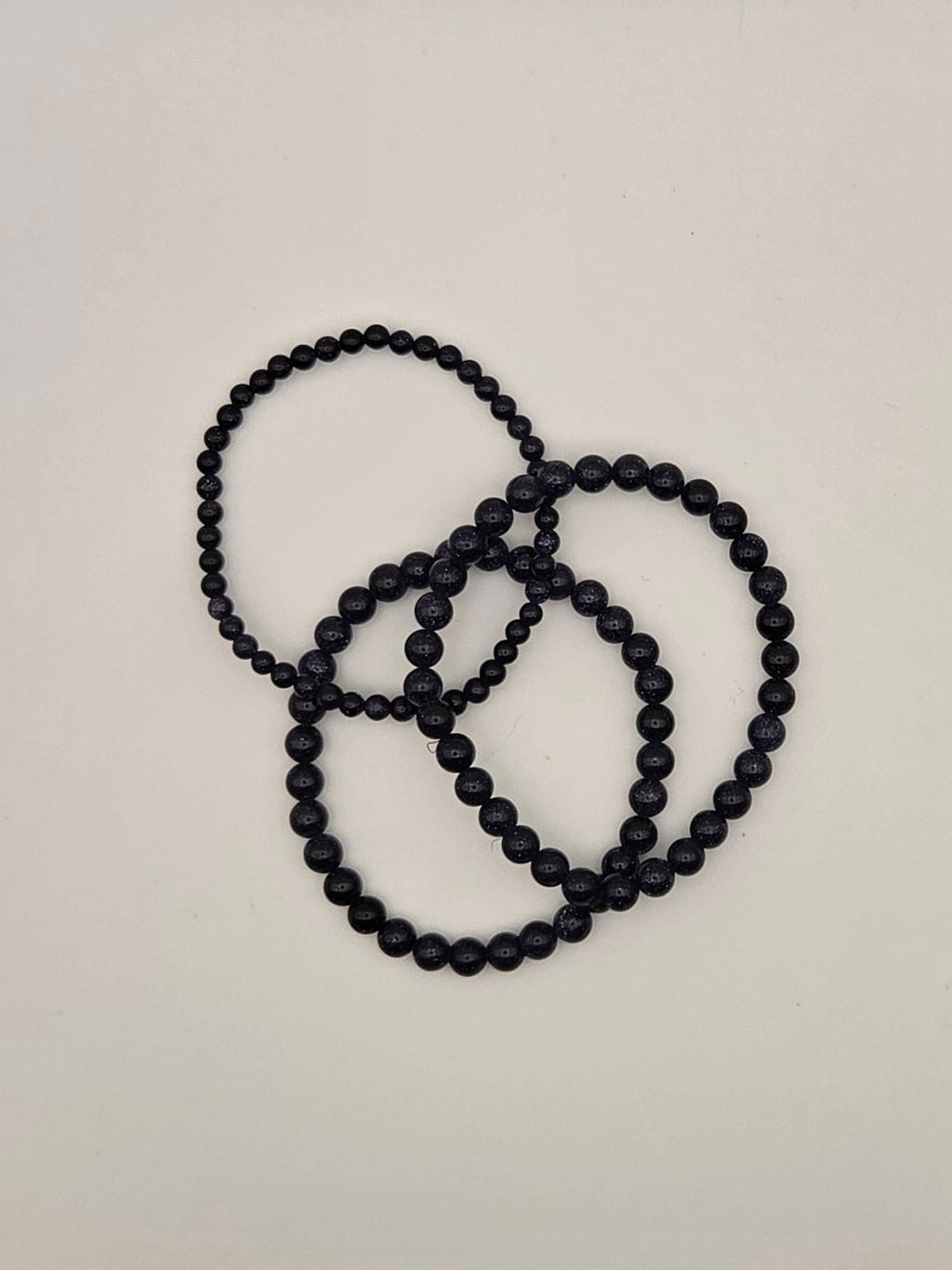 Blue goldstone stretch bracelets showing sparkling midnight blue beads