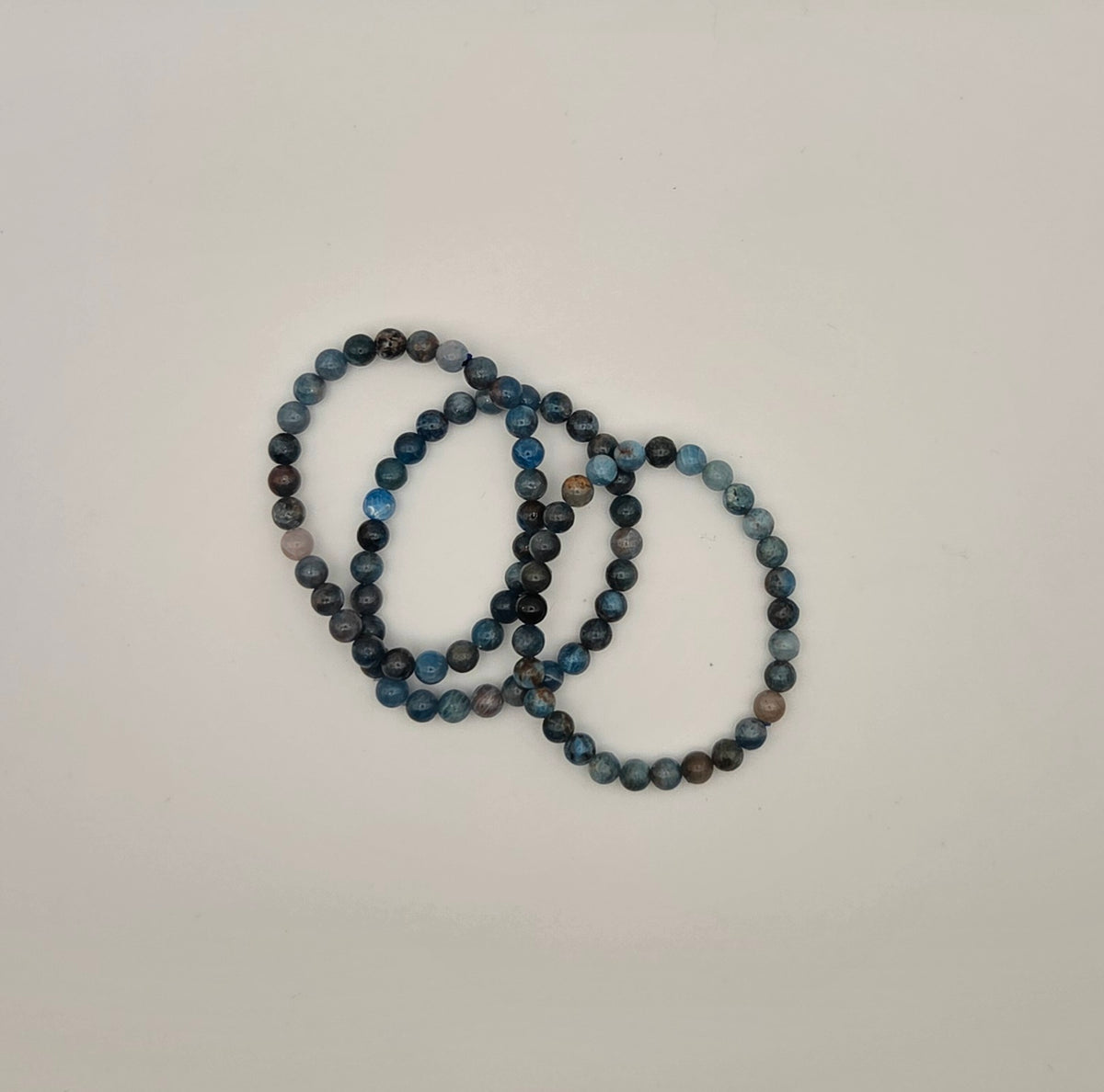 Blue apatite beaded bracelets showing natural variations in blue teal gray and earthy stone beads