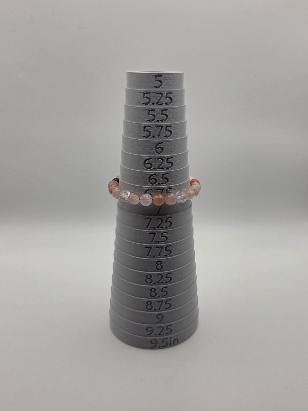 Mandrel: 8mm fire quartz stretch bracelet displayed on a bracelet sizing mandrel