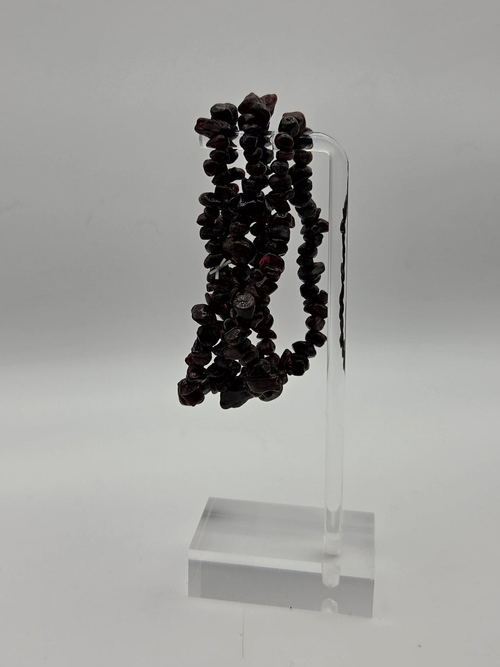 Garnet chip stretch bracelets displayed on a clear acrylic jewelry stand